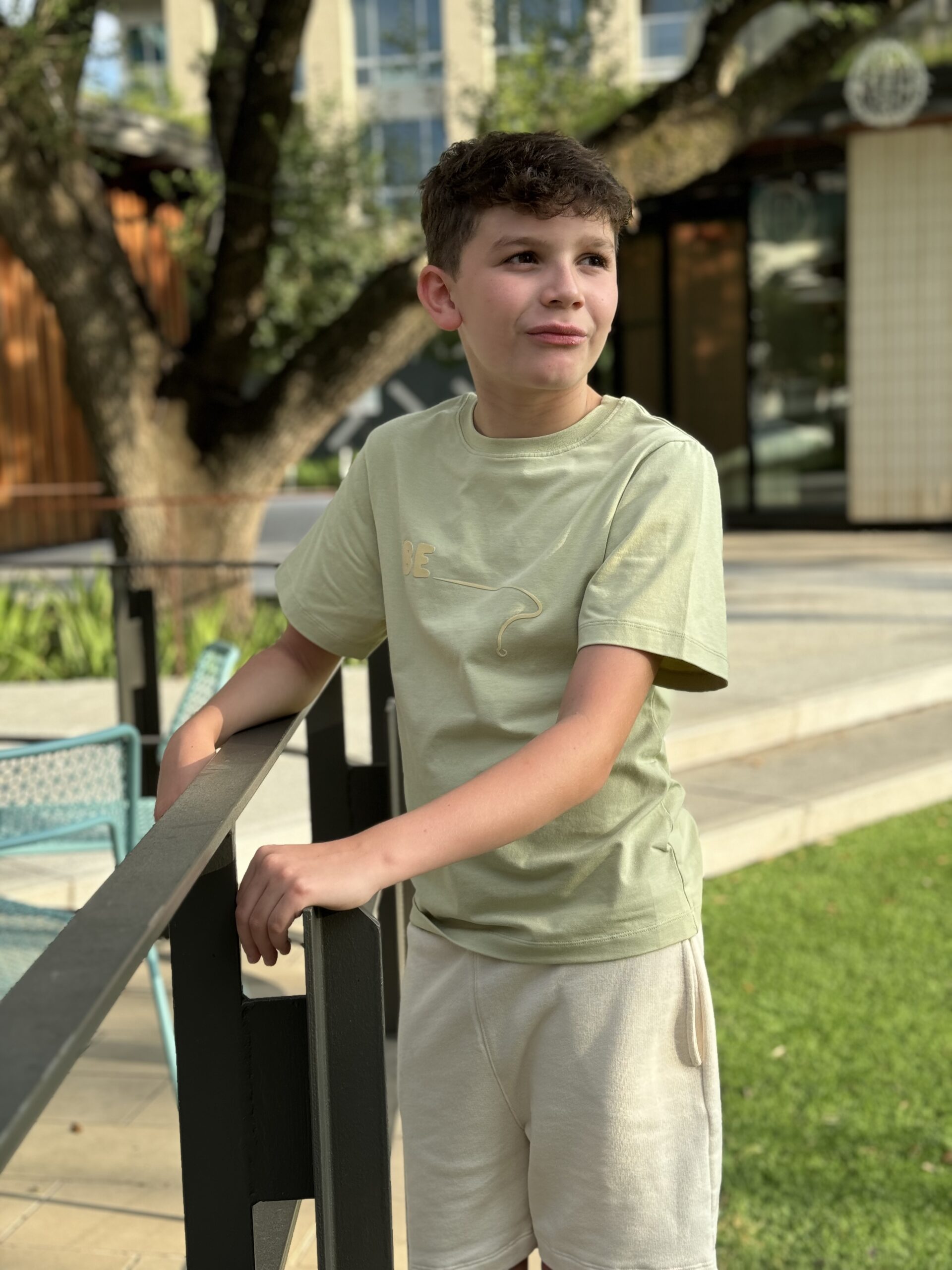 bekids-boy-cream-shorts-olive-tshirt Young boy in BE.Kids Cream shorts and Olive Green T-shirt, eco-friendly fashion for kids