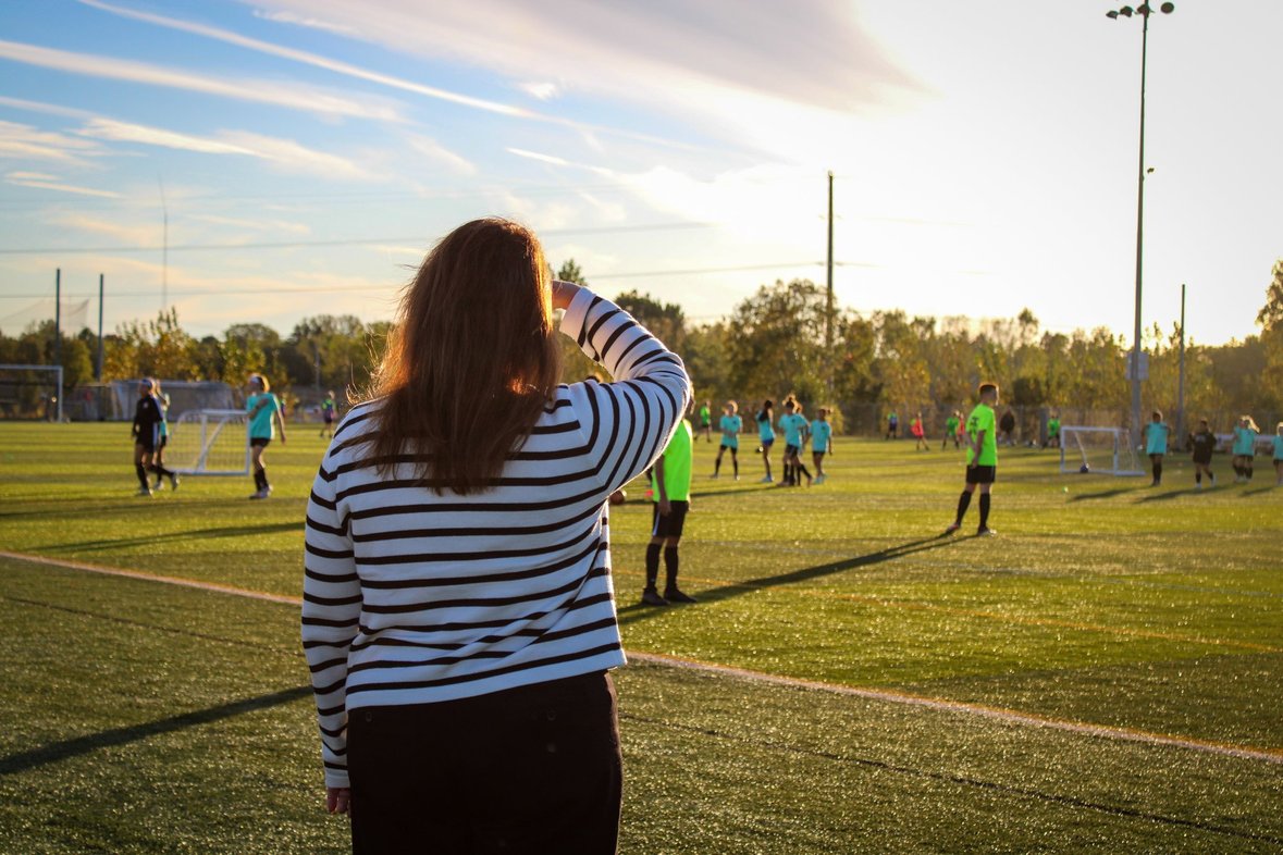 Christine watching her son play soccer