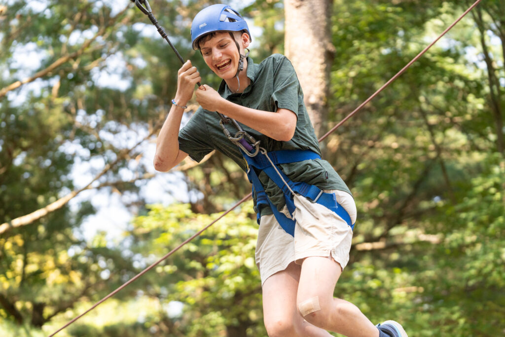Choosing the Right Camp for a Child with a Disability. In this photo, a camper takes flight from a zipline!