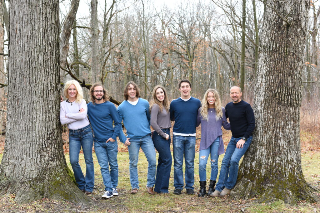 Anna Marcolin, therapy, podcast host, poses with her family of 5 children and her husband.