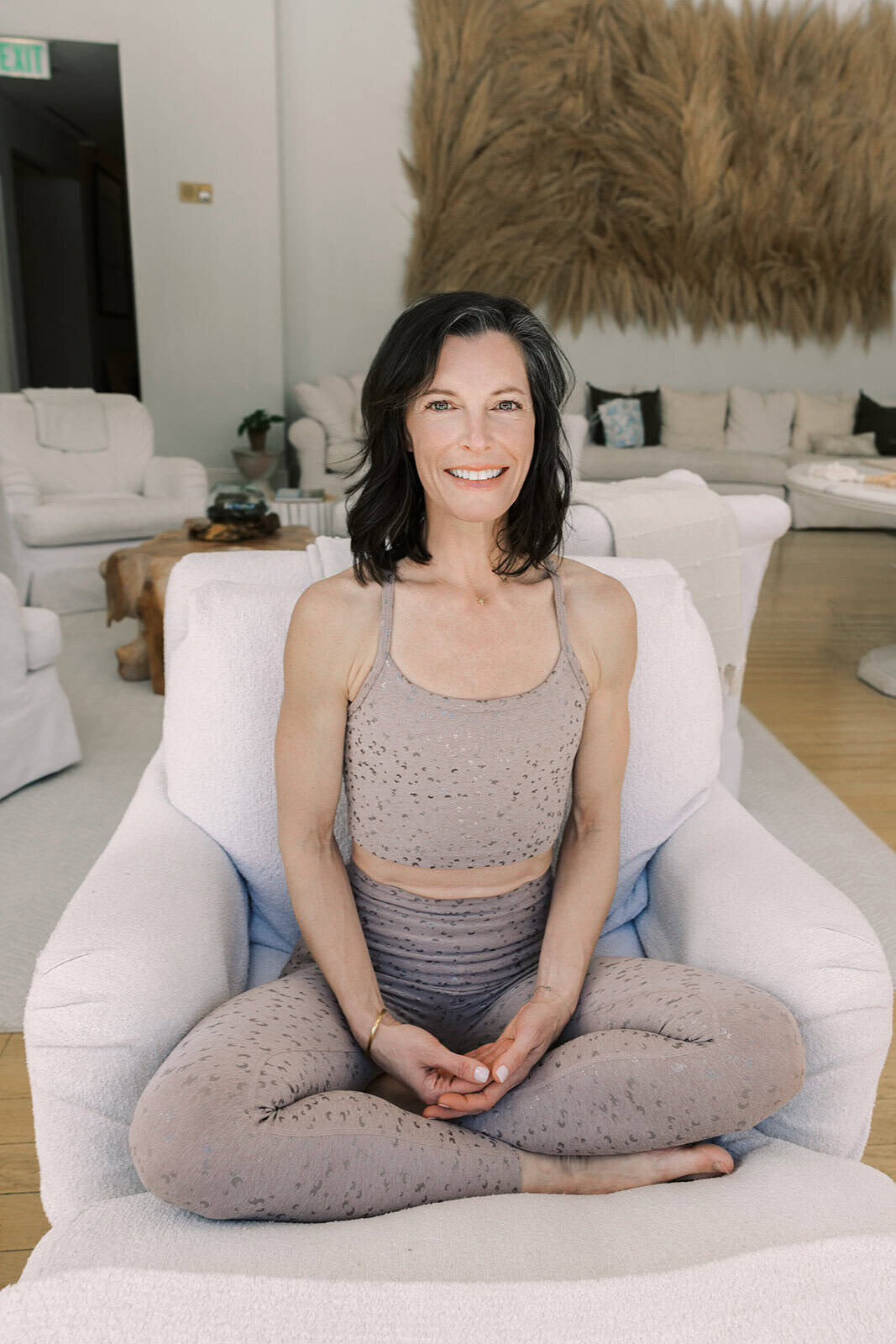 Woman practicing yoga in a bright, modern living room with cozy decor.