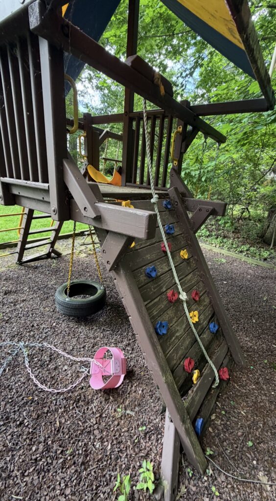 aging wooden backyard playset showing signs of wear