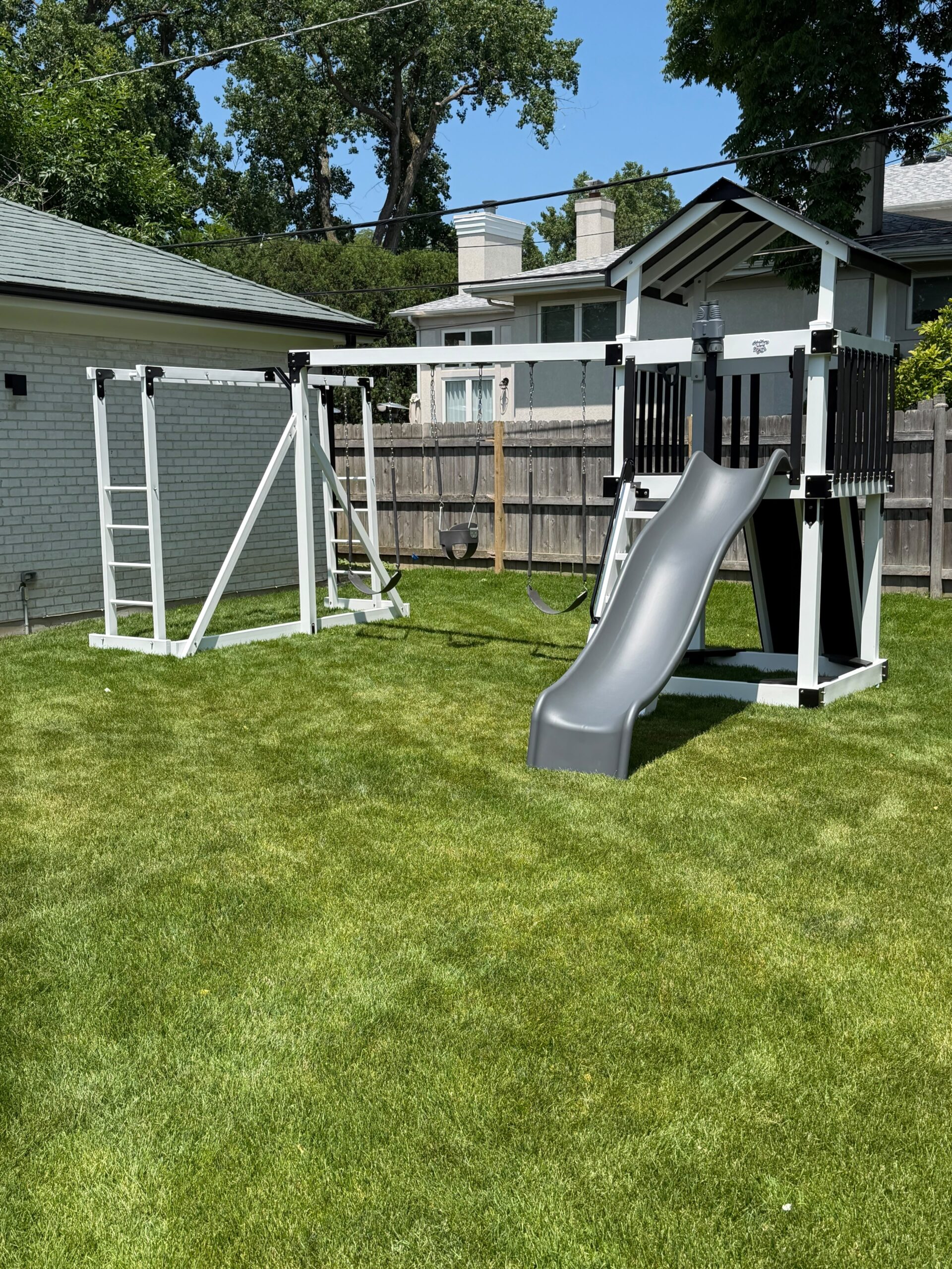 Modern vinyl backyard playset installed on a lawn