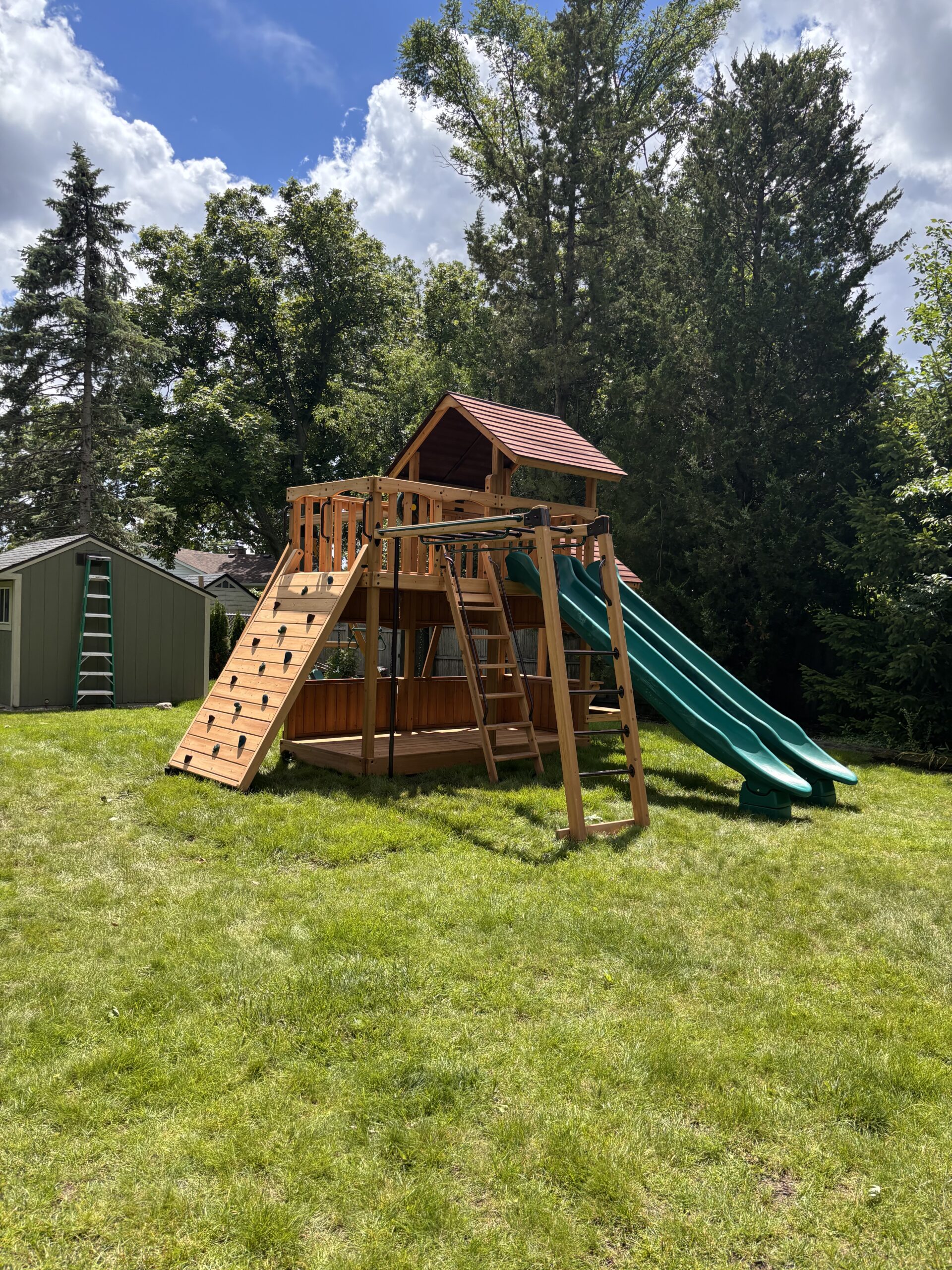 New wooden swing set and playset in a family backyard