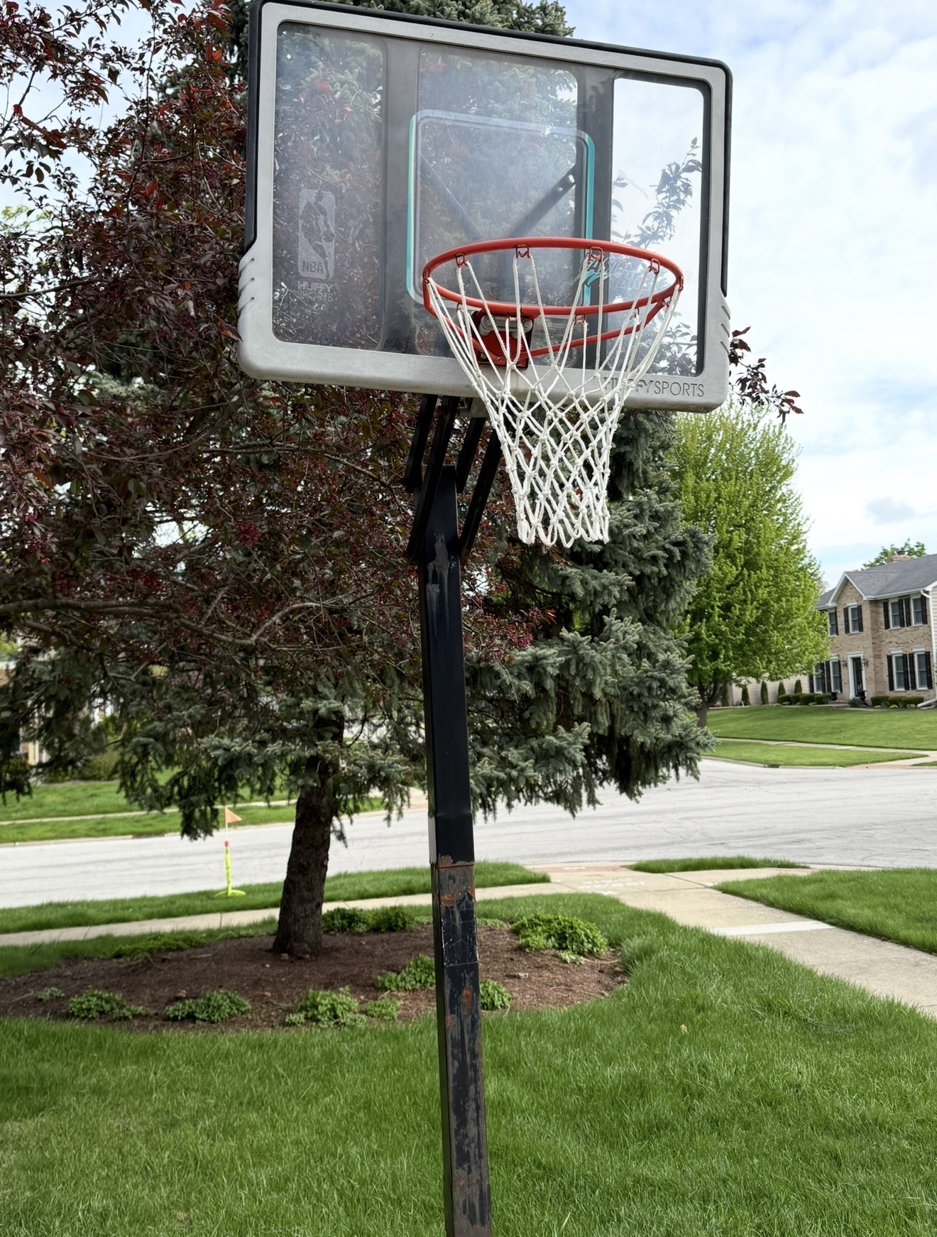 damaged residential basketball hoop with a cracked backboard